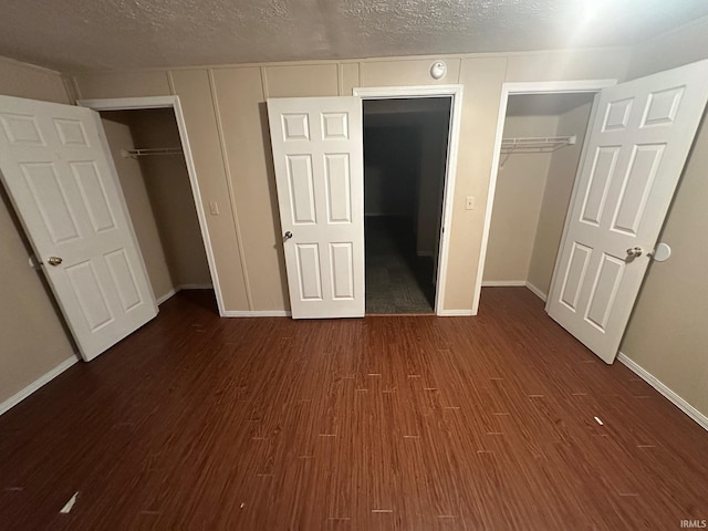 unfurnished bedroom with dark hardwood / wood-style flooring and a textured ceiling