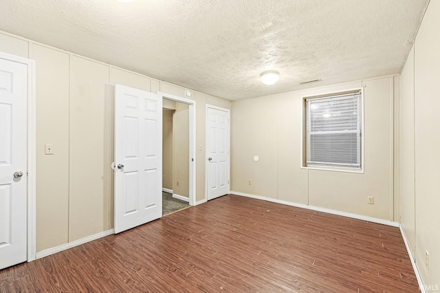 unfurnished bedroom featuring wood-type flooring and a textured ceiling