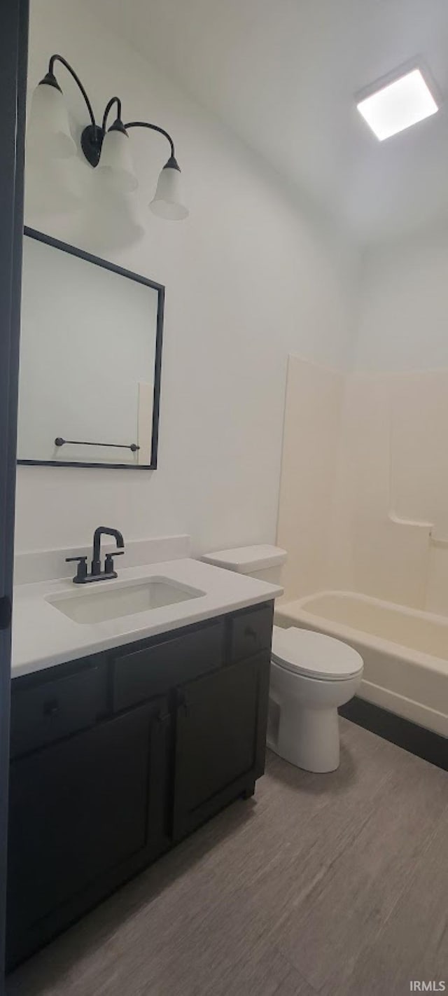 full bathroom with vanity, hardwood / wood-style flooring, toilet, and tub / shower combination