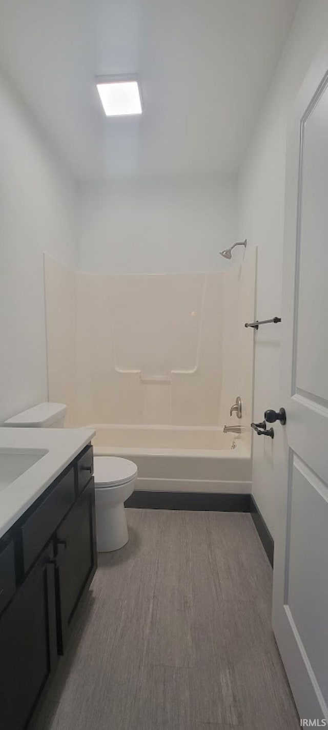 full bathroom featuring toilet, hardwood / wood-style floors, vanity, and washtub / shower combination