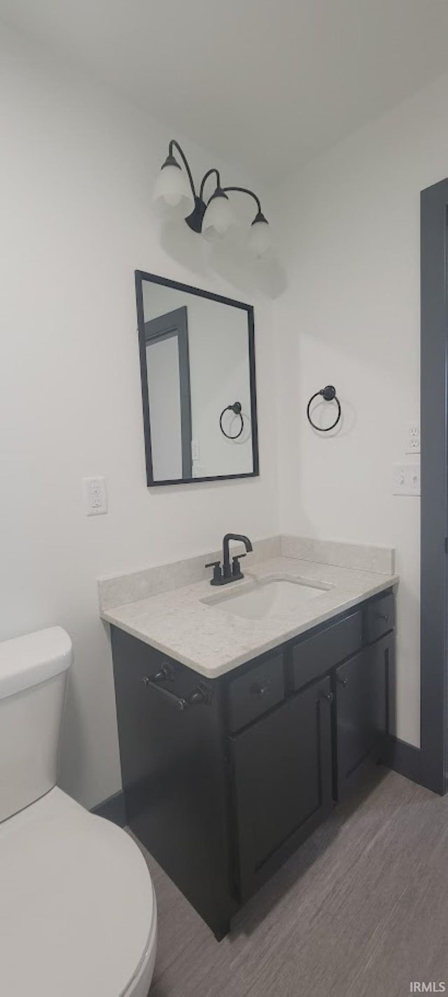 bathroom featuring vanity, hardwood / wood-style flooring, and toilet