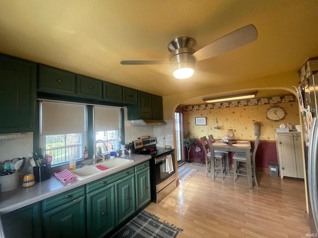 kitchen with a textured ceiling, sink, green cabinets, and stainless steel electric range