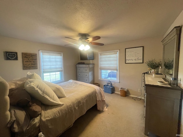 bedroom with ceiling fan, carpet floors, and a textured ceiling