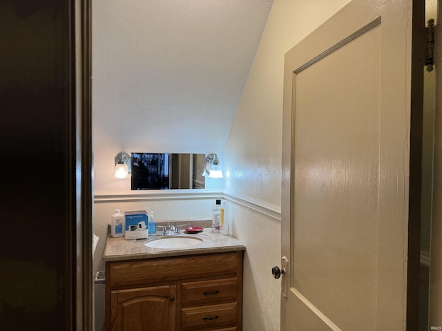 bathroom featuring vanity and lofted ceiling