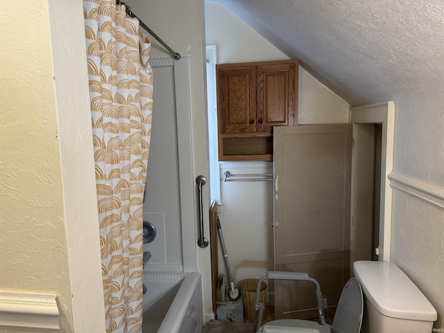 bathroom featuring toilet, lofted ceiling, a textured ceiling, and shower / tub combo