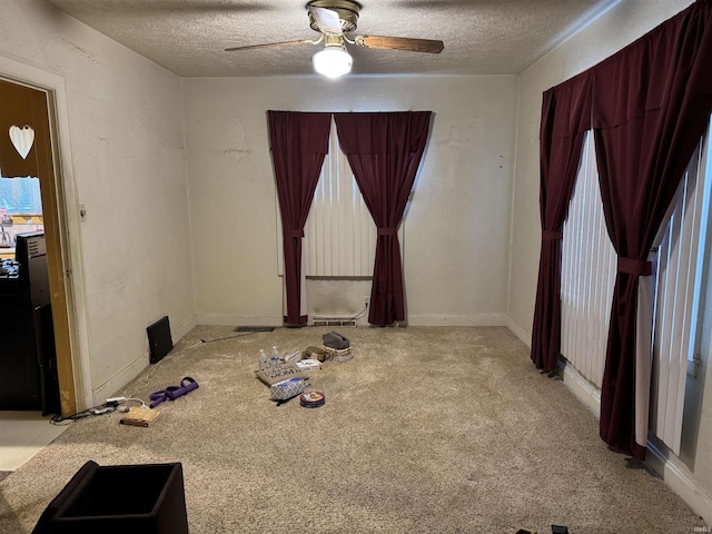 unfurnished room featuring a textured ceiling, light colored carpet, and ceiling fan