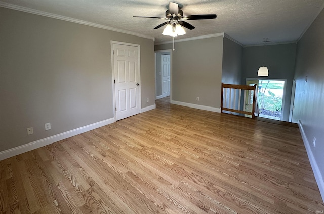 spare room with ceiling fan, ornamental molding, a textured ceiling, and light hardwood / wood-style flooring