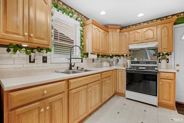 kitchen with tasteful backsplash, sink, white range, and light brown cabinets