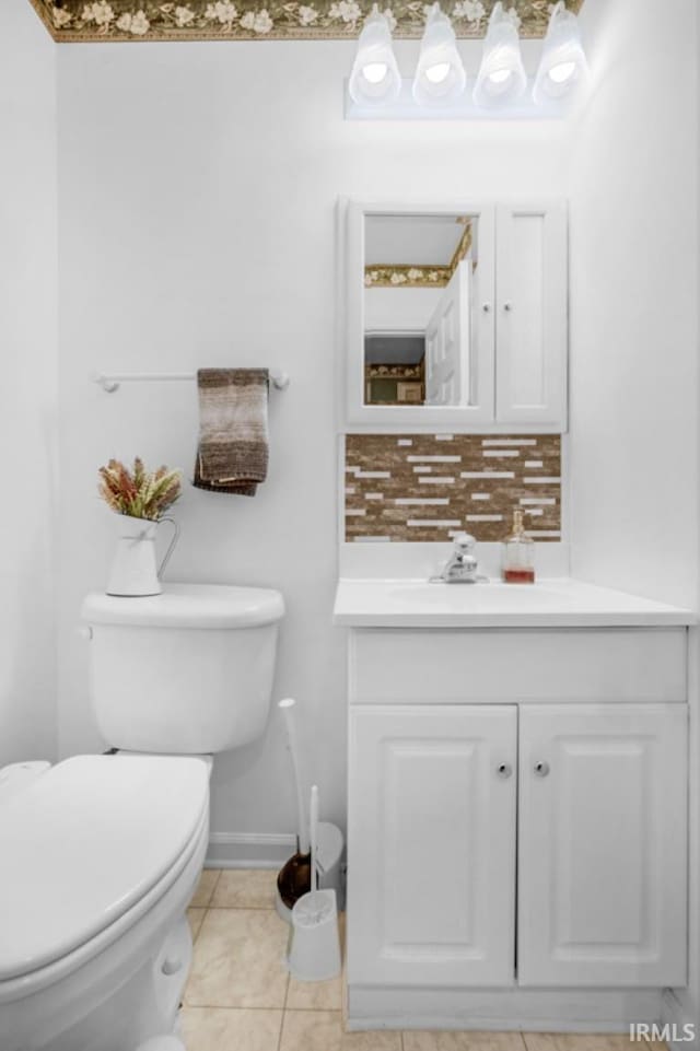 bathroom with tile patterned floors, vanity, tasteful backsplash, and toilet