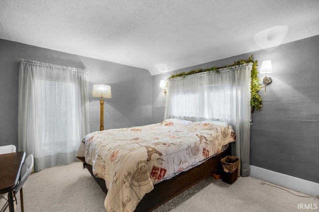 bedroom with light colored carpet and a textured ceiling