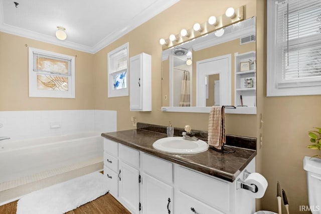 bathroom with hardwood / wood-style flooring, vanity, ornamental molding, and a tub to relax in