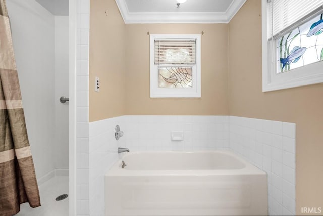 bathroom with a bath, a wealth of natural light, and ornamental molding