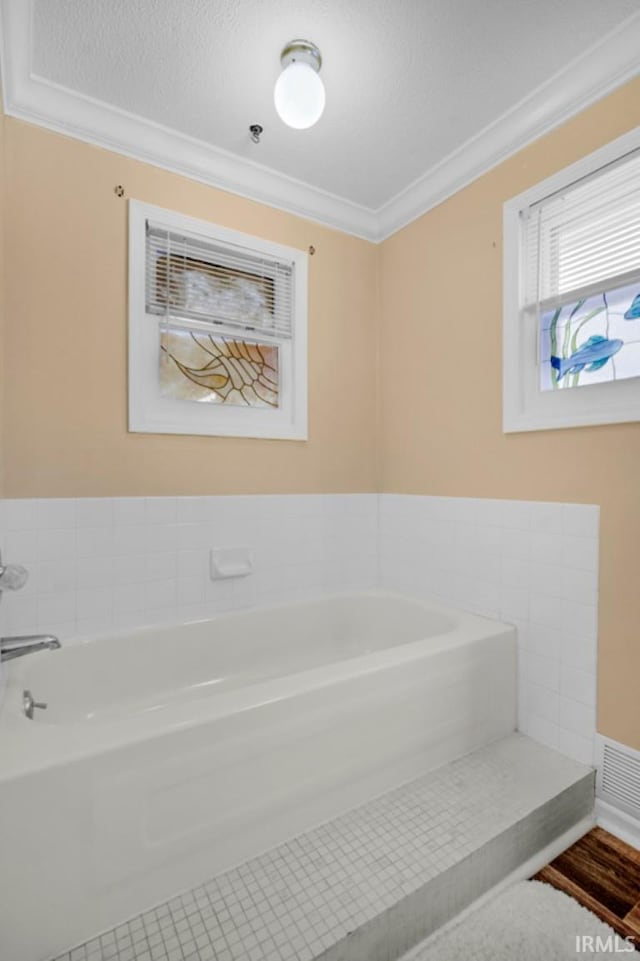 bathroom featuring a bathing tub and ornamental molding