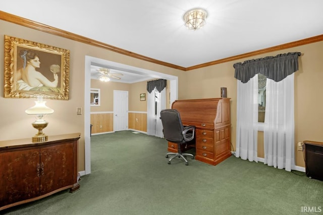 office area featuring dark colored carpet, ceiling fan, wood walls, and crown molding