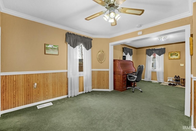 unfurnished office featuring dark carpet, ceiling fan, and crown molding