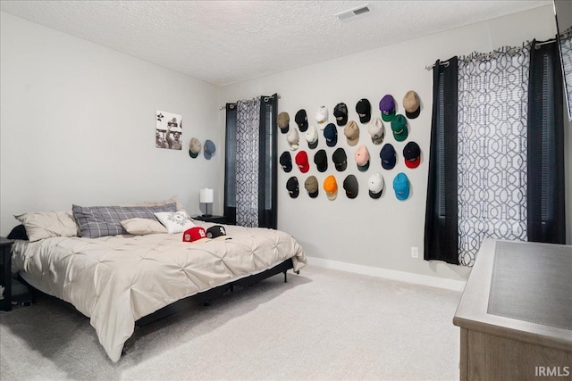 bedroom with carpet floors and a textured ceiling