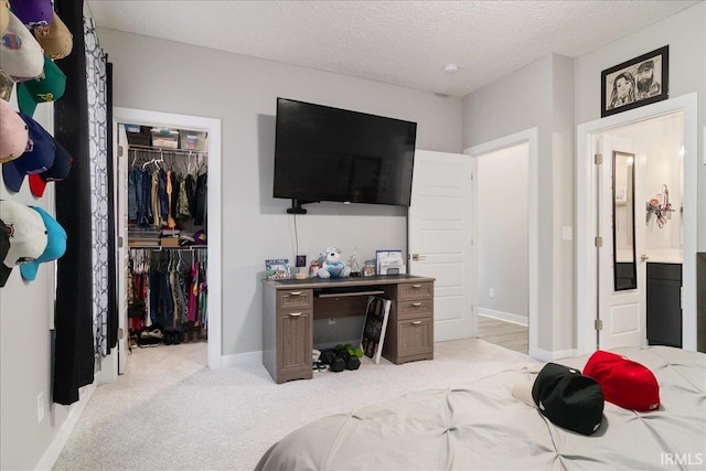 bedroom featuring a textured ceiling, light carpet, and a closet