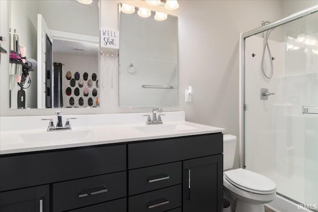 bathroom featuring vanity, an enclosed shower, and toilet