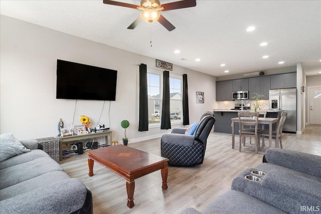 living room with ceiling fan and light wood-type flooring