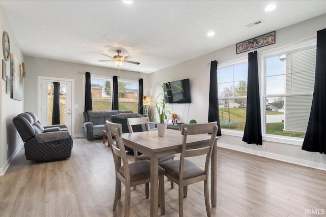 dining area featuring a textured ceiling, hardwood / wood-style flooring, and ceiling fan