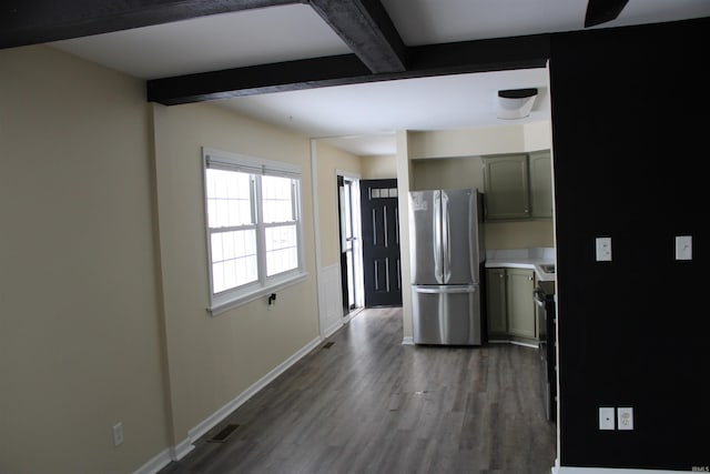 kitchen with gray cabinetry, beam ceiling, dark wood-type flooring, and stainless steel refrigerator