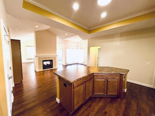 kitchen featuring a tile fireplace, a center island, and a healthy amount of sunlight