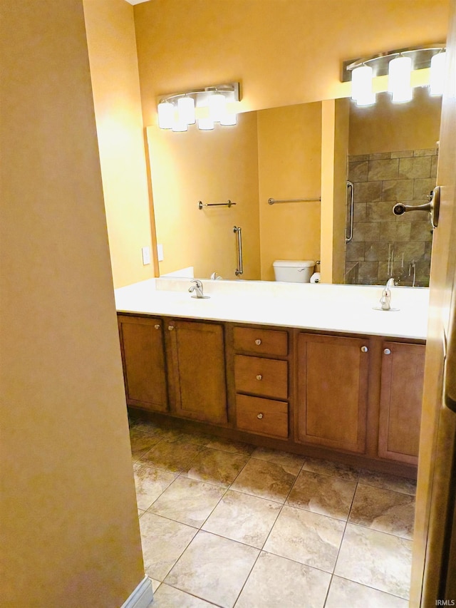 bathroom with tile patterned flooring, vanity, toilet, and walk in shower