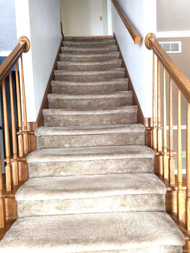 stairs featuring hardwood / wood-style floors and a textured ceiling