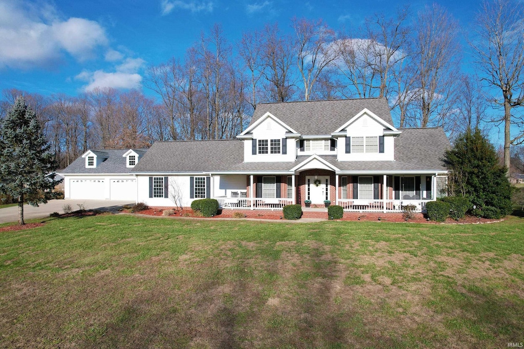 view of front facade featuring a garage, covered porch, and a front yard