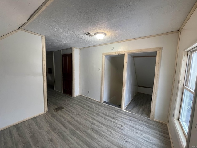 unfurnished room with a textured ceiling and hardwood / wood-style flooring