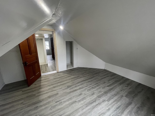 bonus room with hardwood / wood-style flooring, lofted ceiling, and a textured ceiling