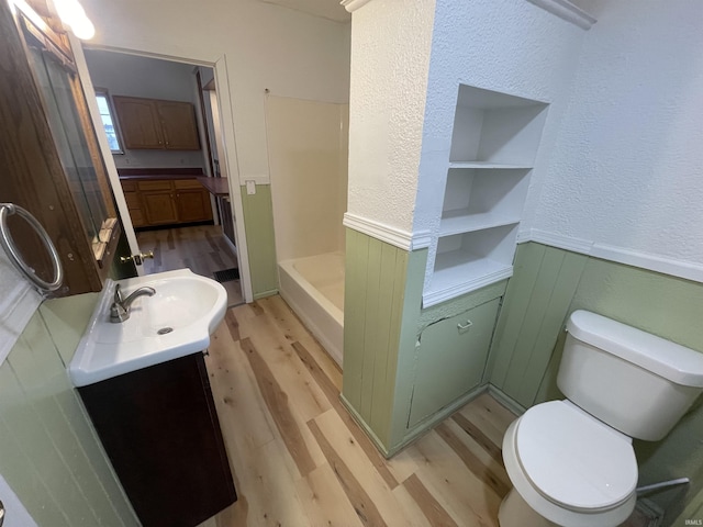 bathroom featuring vanity, built in features, toilet, and wood-type flooring