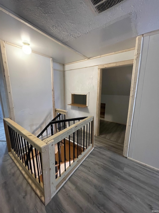 hall featuring dark wood-type flooring and a textured ceiling