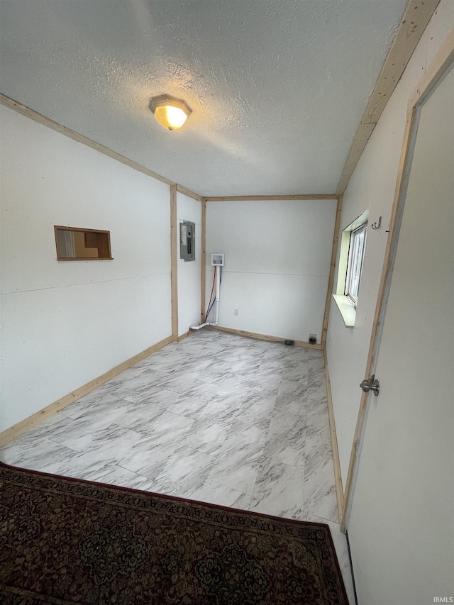 unfurnished room featuring a textured ceiling and electric panel