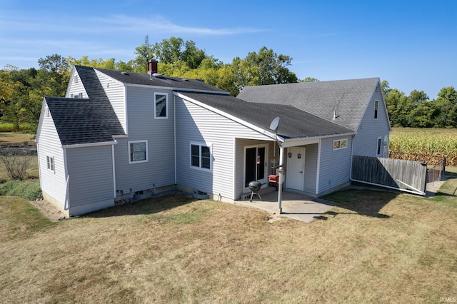 back of property with a lawn and a patio