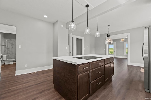 kitchen with pendant lighting, a center island, black electric cooktop, and stainless steel refrigerator