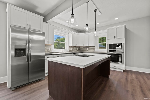 kitchen with sink, hanging light fixtures, a kitchen island, stainless steel refrigerator with ice dispenser, and white cabinets