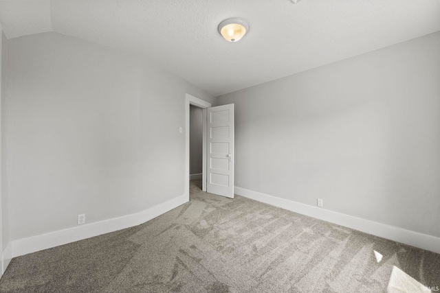 unfurnished room featuring carpet floors and vaulted ceiling