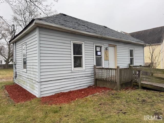 back of house featuring a lawn and a wooden deck