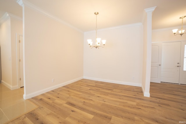 spare room featuring hardwood / wood-style floors, a notable chandelier, and crown molding