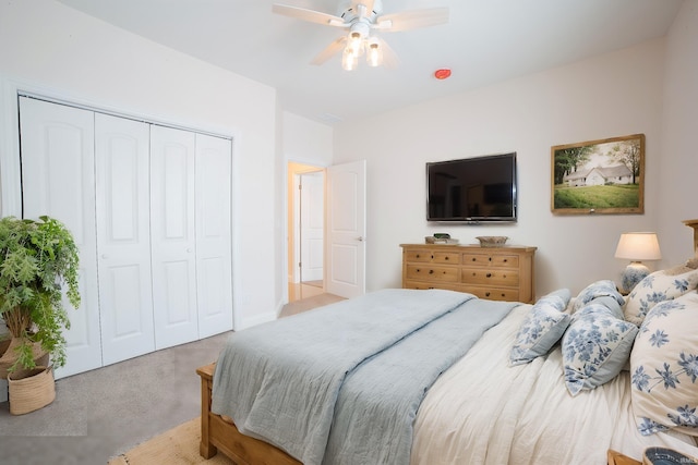 bedroom with ceiling fan, light carpet, and a closet