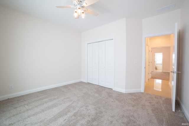 unfurnished bedroom with ceiling fan, carpet floors, and a closet