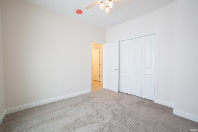 unfurnished bedroom with ceiling fan, a closet, and light colored carpet