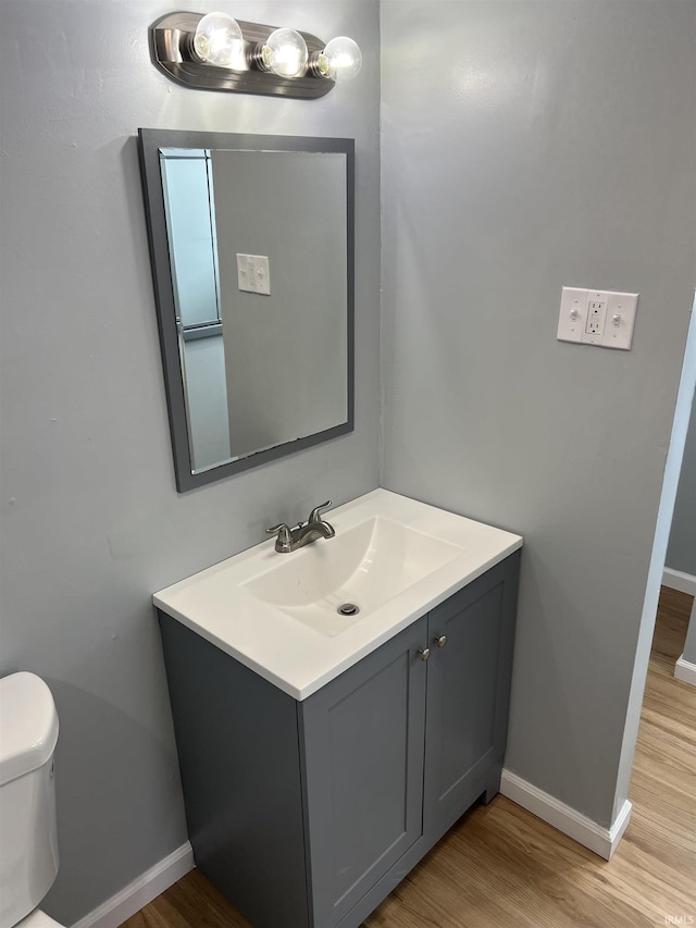 bathroom featuring vanity, hardwood / wood-style flooring, and toilet