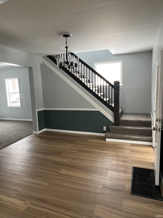 stairs with carpet floors and an inviting chandelier