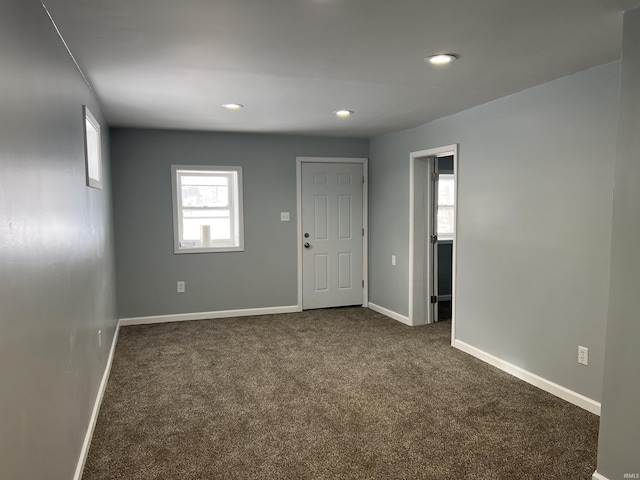 spare room featuring dark carpet