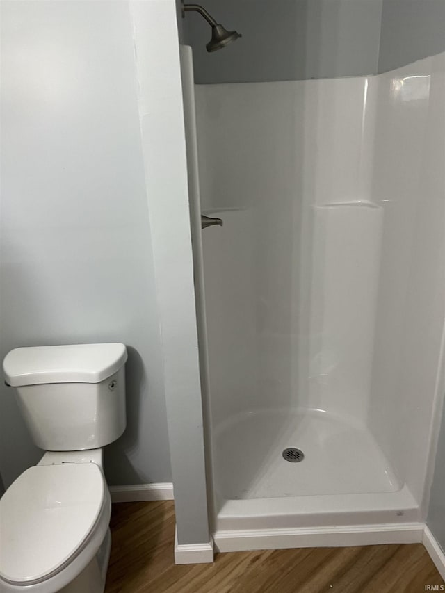 bathroom featuring hardwood / wood-style floors, toilet, and walk in shower