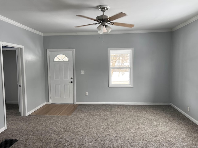 entrance foyer featuring crown molding, ceiling fan, and dark colored carpet