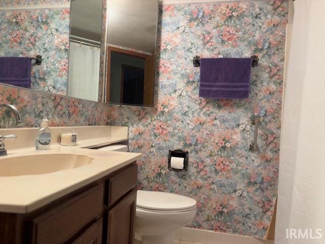 bathroom featuring tile patterned floors, vanity, and toilet