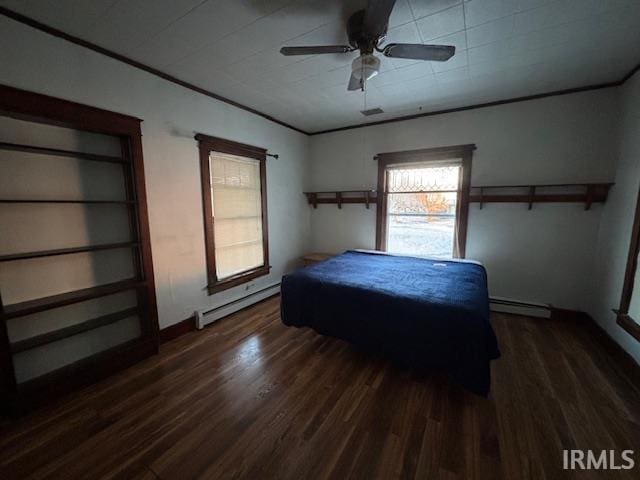 bedroom with crown molding, baseboard heating, dark wood-type flooring, and ceiling fan